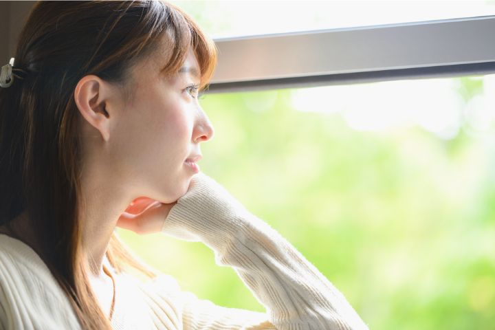 明るい外を眺める女性の横顔
