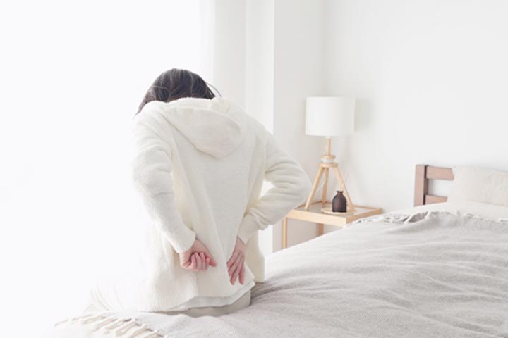 寝起きで腰を気遣う女性