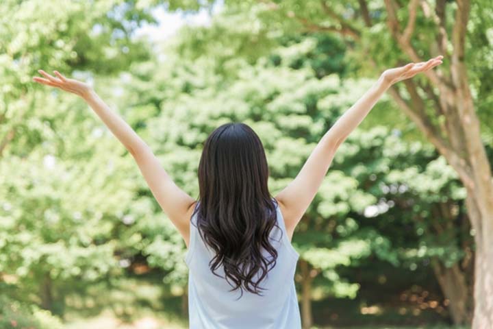 背伸びをして深呼吸している女性